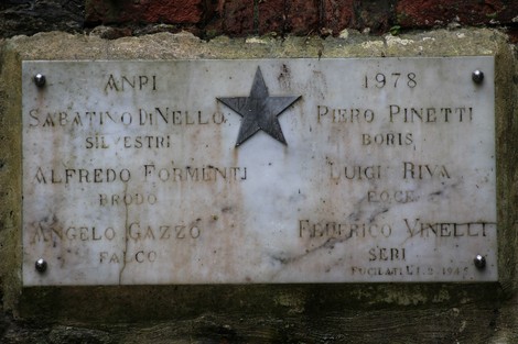 Lapide commemorativa con nomi di caduti, simbolo della resistenza e della memoria storica.