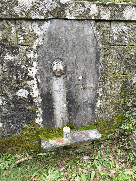 Sepolcri delle vittime di Giuncheto, monumento commemorativo con lapide e foto, immerso nella natura.