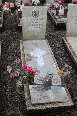 Tombe con fiori e candele, dedicate ai caduti per la Libertà, in un cimitero commemorativo.