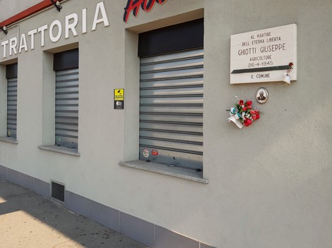 Lapide commemorativa in memoria di Ghiotti Giuseppe, martire della libertà, situata sulla facciata di una trattoria.