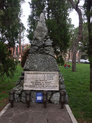 Monumento commemorativo alle vittime del primo bombardamento su Imola, situato in un contesto verde e tranquillo.