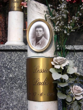 Monumento commemorativo ai martiri della Garella, con fiori e ritratto incorniciato.