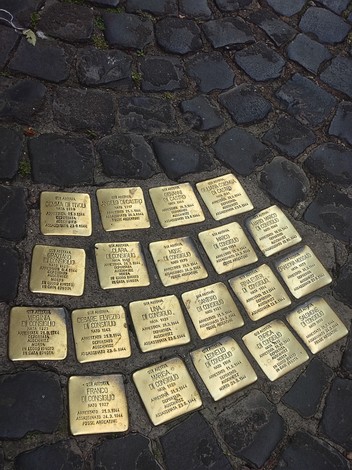 Pietre d'inciampo dedicate alle famiglie Di Consiglio, Di Tivoli, Di Castro e Moscato, su un basolato di ciottoli.
