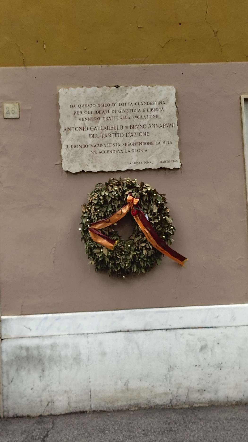 Lapide commemorativa con una corona d'alloro, in onore di Gallarello e Annarumi.