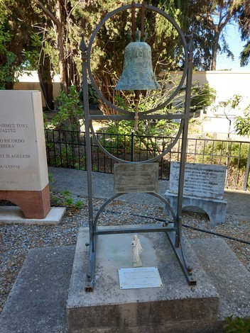 Sacrario dei caduti di Kos, monumento con una campana e una statua commemorativa circondato da un giardino.