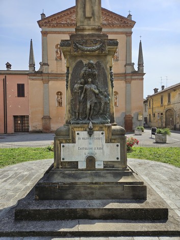 Monumento ai Caduti di Castiglione d'Adda, con statue e dettagli architettonici, immerso in un ambiente urbano.