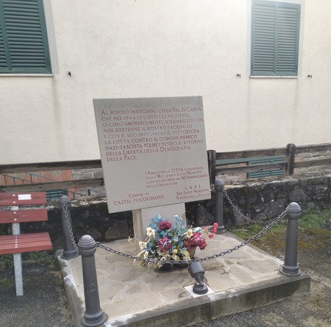 Monumento al popolo partigiano della Val di Carda, commemorativo con fiori e dedica alla lotta per la libertà.