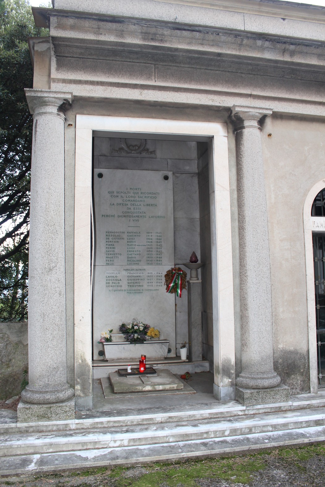 Sacrario dei caduti per la Libertà di Cornigliano, monumento commemorativo con fiori e lumini accesi.