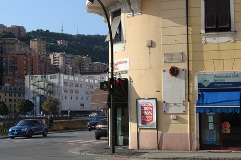 Lapide commemorativa dedicata ai caduti per la Libertà, situata a Marassi, con edificio e strada circostante.