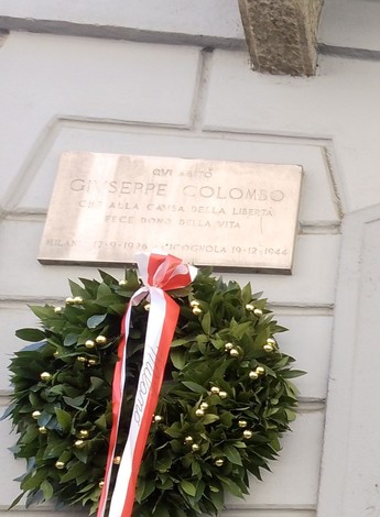 Lapide commemorativa dedicata a Giuseppe Colombo, adornata con una corona di alloro.