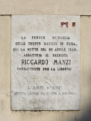 Lapide commemorativa in onore di Riccardo Manzi, patriota ucciso durante la resistenza contro i nazisti.
