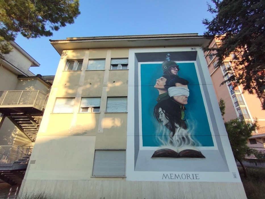Murale "Eroi ottobrini" su edificio, raffigurante figure storiche avvolte in simbolismi evocativi.