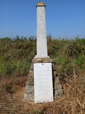 Cippo commemorativo dedicato ai sette partigiani di Breda Cisoni, situato in un'area rurale.