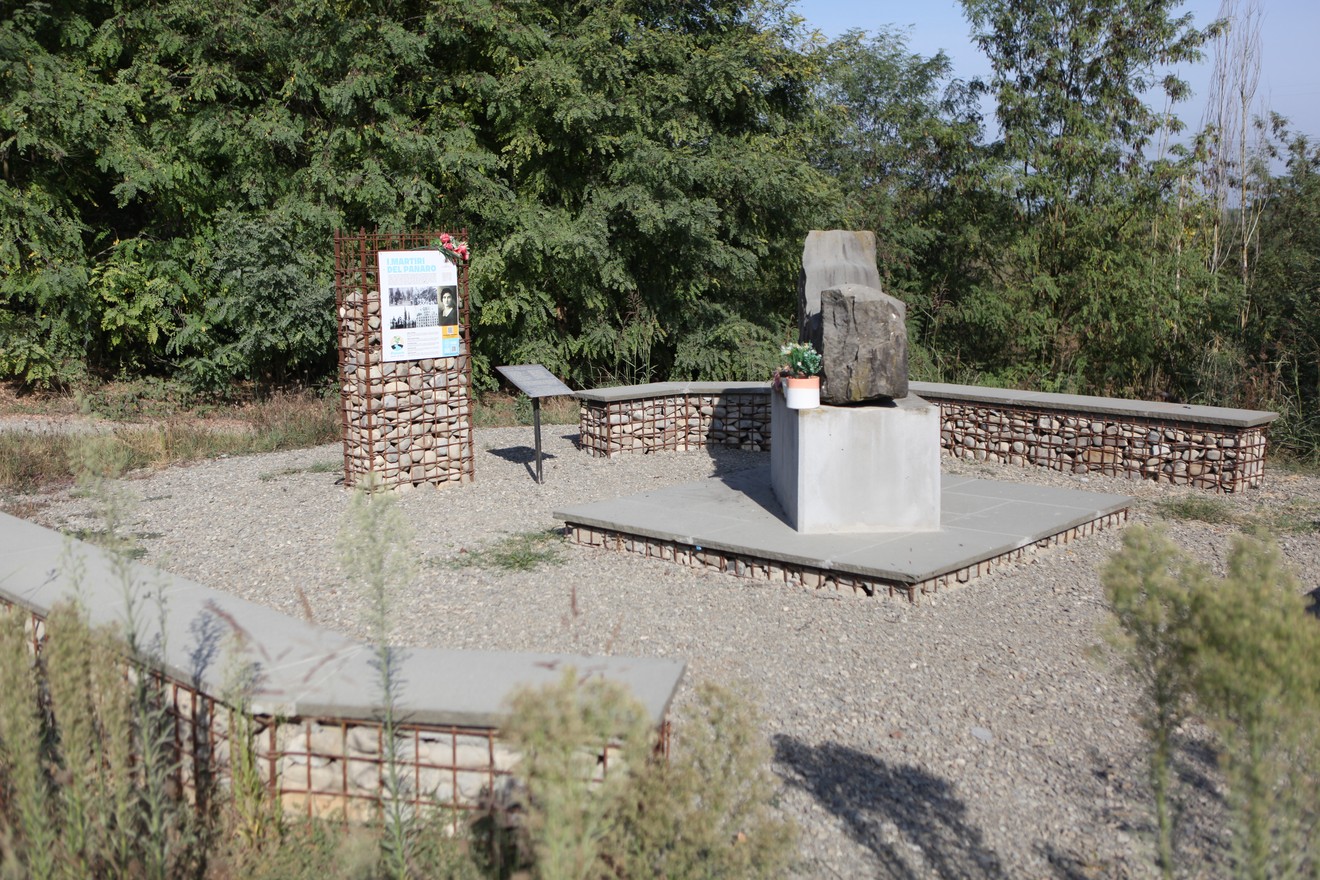 Monumento ai Martiri del Panaro, un luogo commemorativo circondato da vegetazione e architettura in pietra.