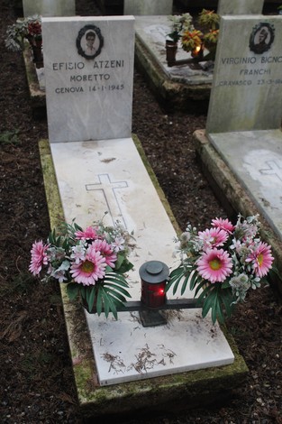 Tombe perpetue con fiori e lanterna, dedicate ai caduti per la libertà in un cimitero.