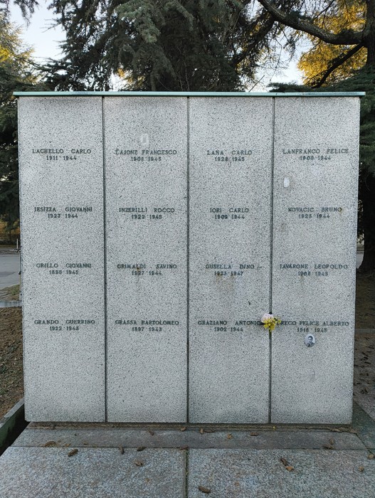 Monumento commemorativo con nomi incisi, simbolo di memoria e rispetto per i defunti.