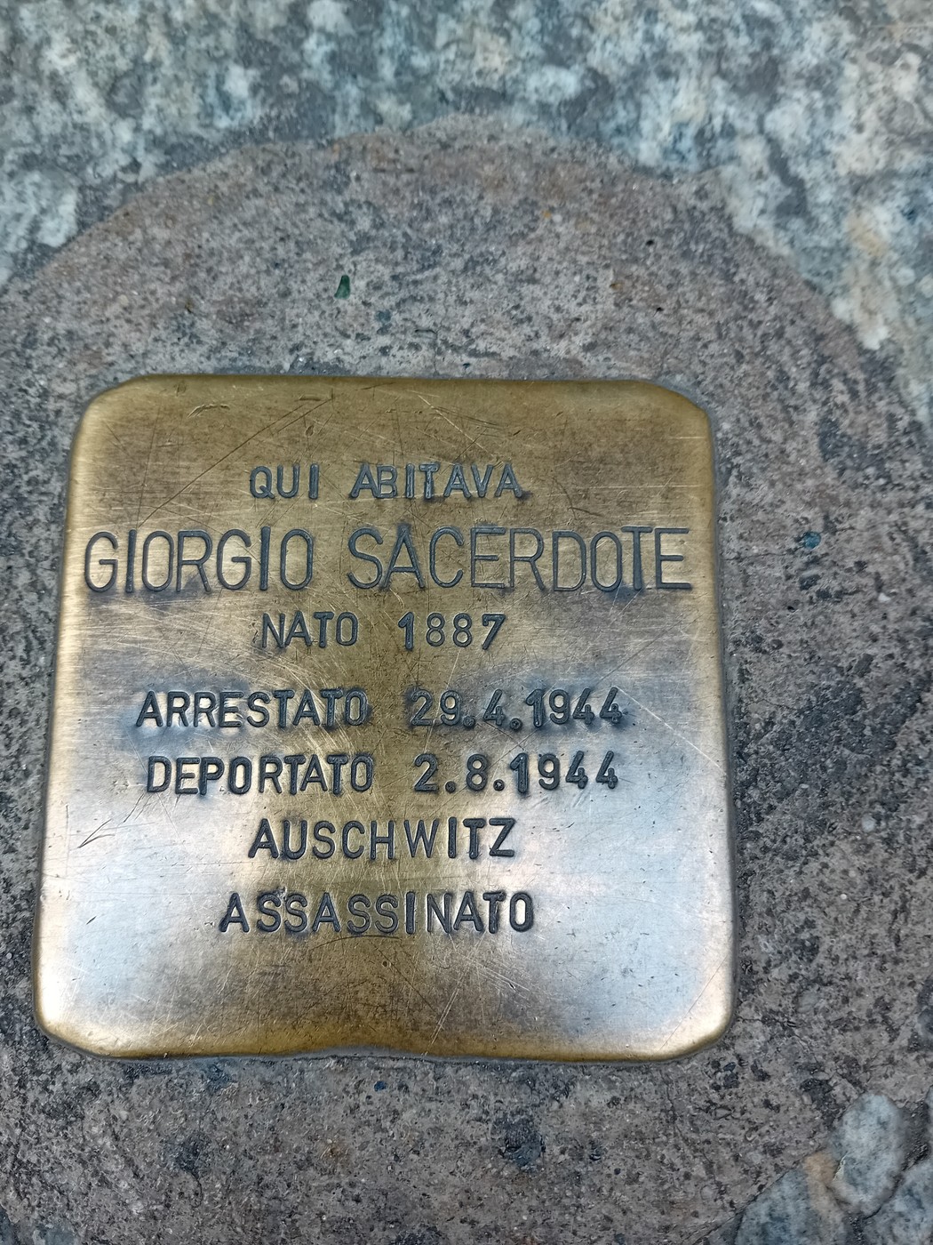 Pietra d'inciampo in ottone incastonata nel selciato, con iscrizione dedicatoria.