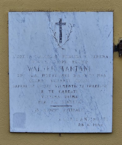 Lapide commemorativa di Walter Martani, con una croce e iscrizioni in onore della sua memoria.