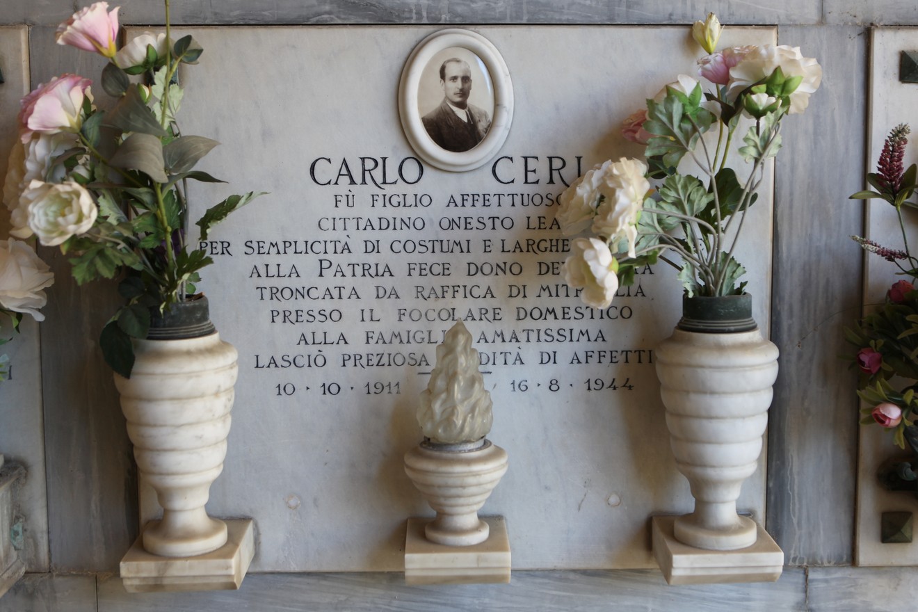 Sepolcro di Ceri con lapide commemorativa e decorazioni floreali in marmo.