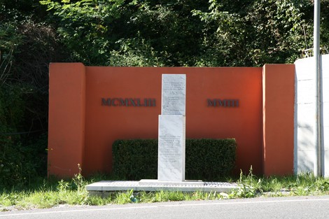 Monumento a Montolli, dedicato alla memoria, situato in un contesto naturale e caratterizzato da elementi architettonici.