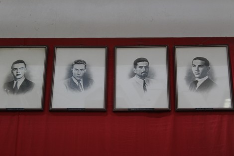 Monumento ai caduti dell'Ansaldo Elettrotecnico con ritratti in bianco e nero su fondo rosso.