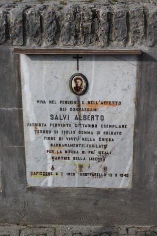 Lapide a Salvi, commemorativa di un patriota e martire della libertà, decorata con una croce e una foto.