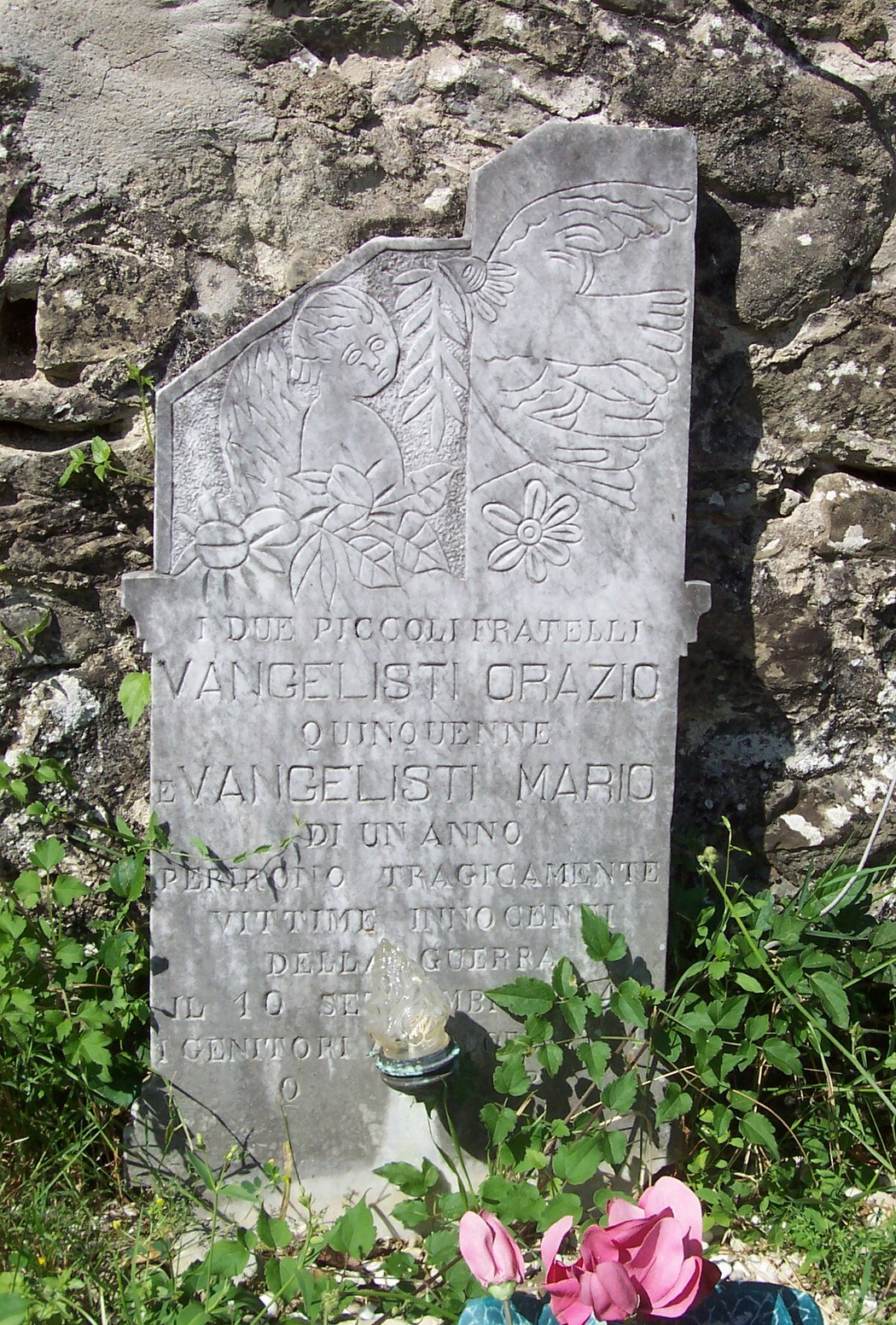 Sepolcro dei fratelli Orazio e Mario, con incisioni decorative e fiori ai piedi della lapide.