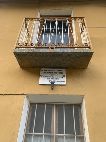 Lapide commemorativa dedicata a Durbiano Vittorio, martire della libertà, affissa su un edificio.