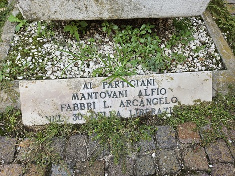 Monumento commemorativo dedicato ai partigiani Mantovani e Fabbri, con dettagli architettonici e vegetazione circostante.