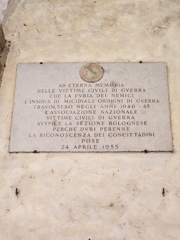 Lapide commemorativa dedicata alle vittime civili di guerra, affissa su un muro, con iscrizioni in memoria.