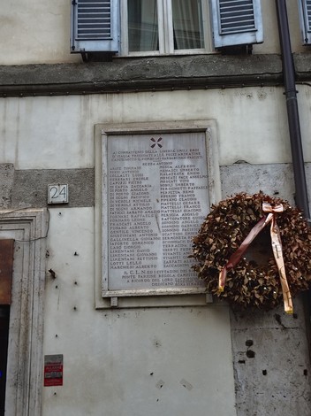 Lapide commemorativa dedicata ai caduti dei rioni Ponte, Parione, Regola e Campitelli, affissa su un muro.