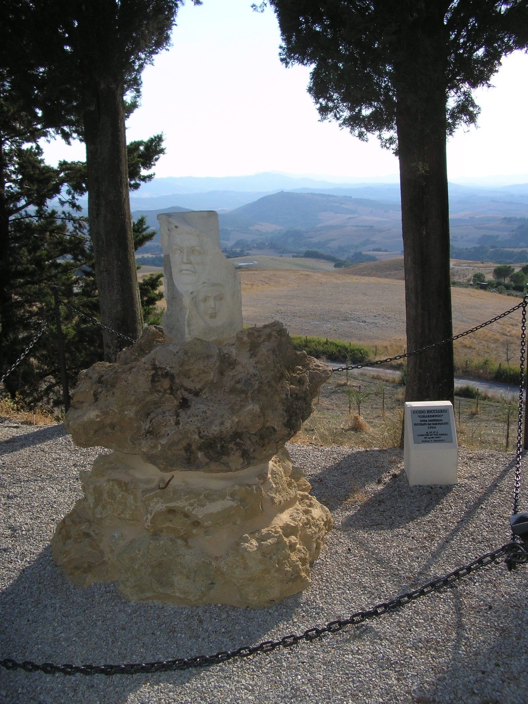 Monumento a Ricciardi: scultura in pietra su base rocciosa, circondata da una vista panoramica sulla campagna.