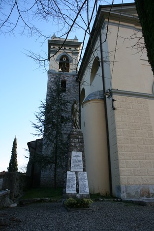 Monumento della chiesa di Farneta, con torre campanaria e statua commemorativa sullo sfondo.