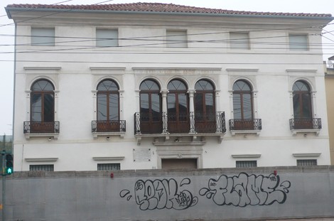 Sede storica del CLN di Mestre, edificio bianco con balconi e graffiti sul muro di cinta.