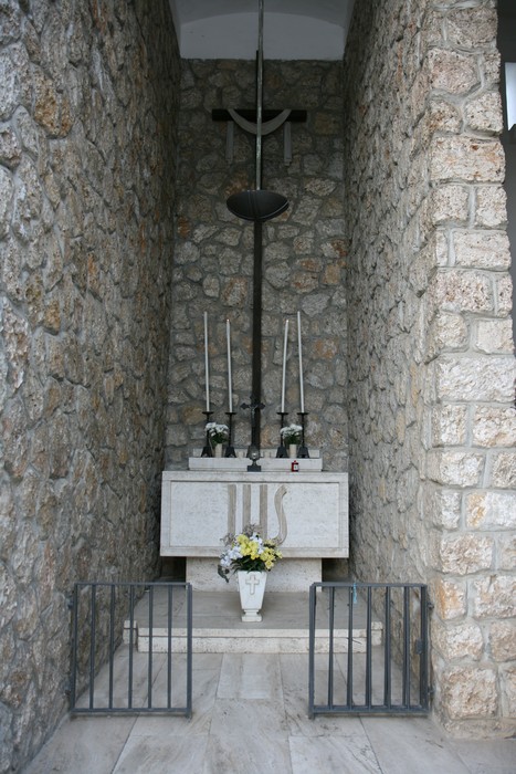Sacrario dei martiri di San Terenzo, monumento in pietra con altarino e decorazioni floreali.