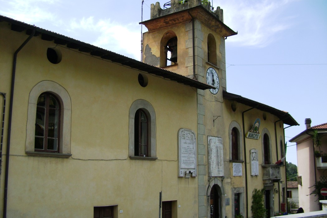Lapide commemorativa dedicata ai caduti partigiani, situata su un edificio storico.