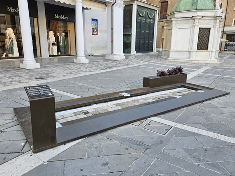 Monumento ai Tre Martiri, una lastra commemorativa in una piazza, dove si distingue il design urbano circostante.