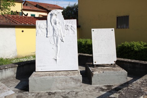 Monumento ai caduti di Soci, con statue e iscrizioni commemorative in un contesto urbano.