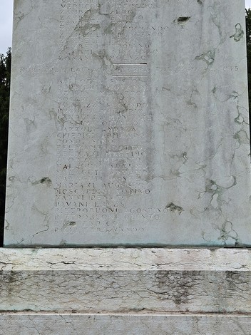 Monumento ai Caduti con iscrizioni commemorative su una struttura in pietra, visibile segni del tempo.