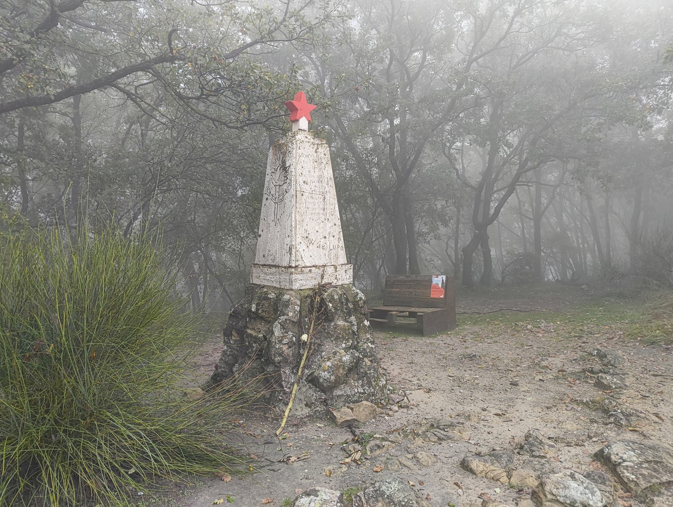 Monumento alla Stella Rossa, dedicato ai caduti di Monte Sole, immerso nella nebbia e nella natura circostante.