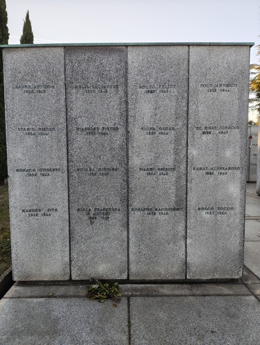 Monumento commemorativo con nomi incisi su lastre di pietra, situato nel Campo della Gloria.