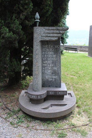 Monumento alla Divisione Acqui, dedicato ai caduti, con iscrizioni commemorative e una fiamma eterna.
