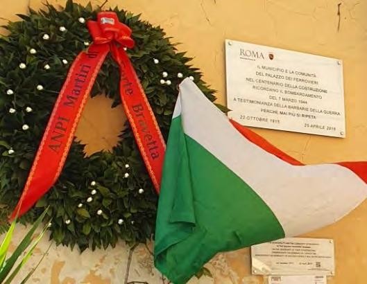 Lapide commemorativa per il bombardamento del 7 marzo, con corona d'alloro e bandiera italiana.