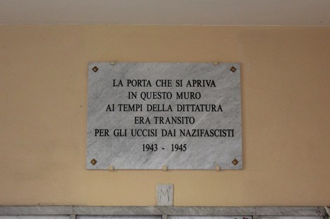 Lapide commemorativa in marmo dedicata agli uccisi dai nazifascisti, con iscrizioni a caratteri neri.
