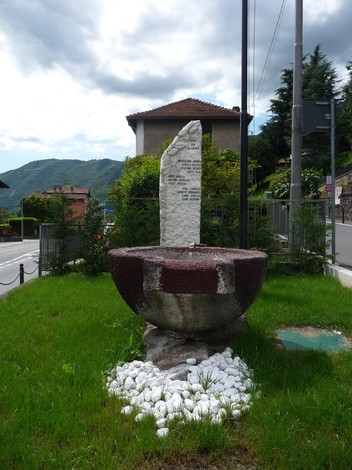 Monumento ai caduti per la Libertà, caratterizzato da una struttura in pietra e una vasca decorativa.