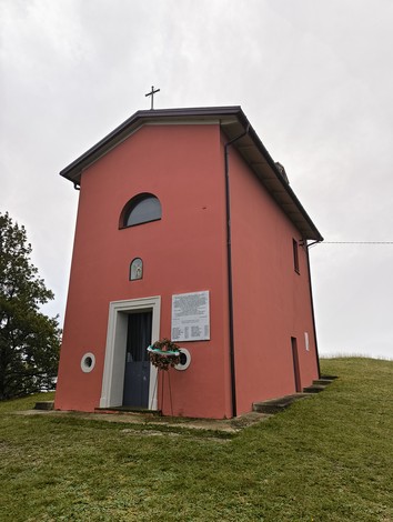 Lapide commemorativa dell'eccidio di Pian di Setta, situata vicino a una piccola chiesa.