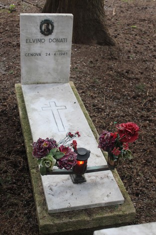 Tombe perpetue dedicate ai caduti per la Libertà, con fiori e lume acceso in un ambiente solenne.