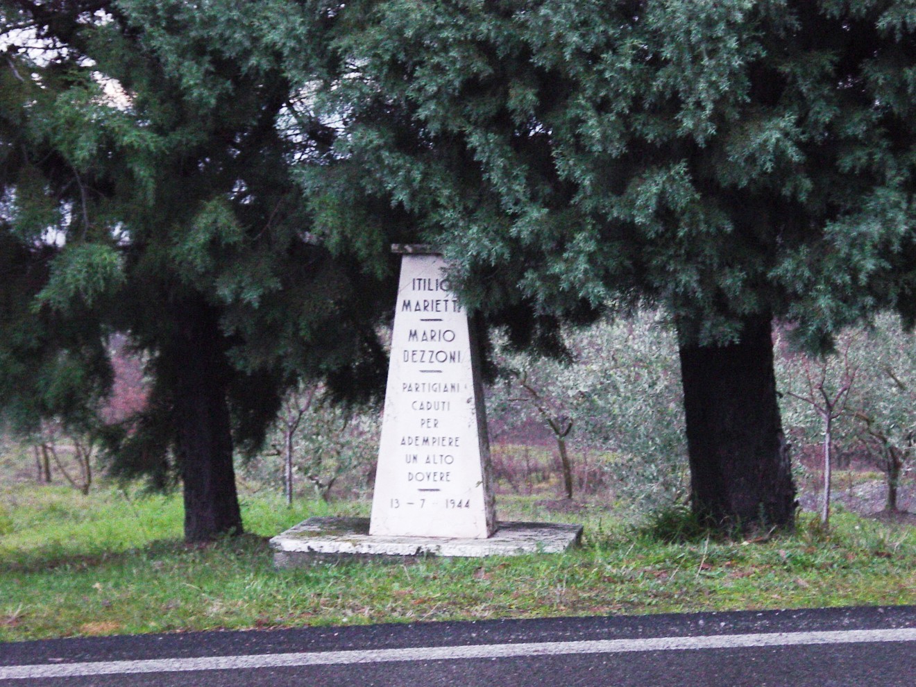 Cippo commemorativo dedicato a Marietti e Dezzoni, partigiani caduti, situato in un'area verde.