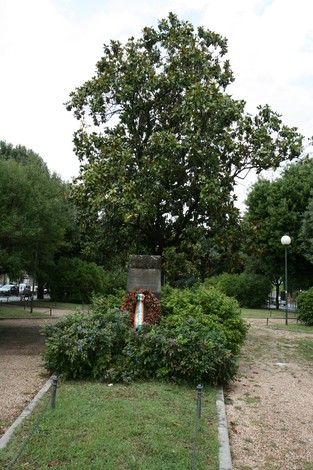 Cippo commemorativo dedicato ai caduti della Liberazione, adornato da un omaggio floreale.