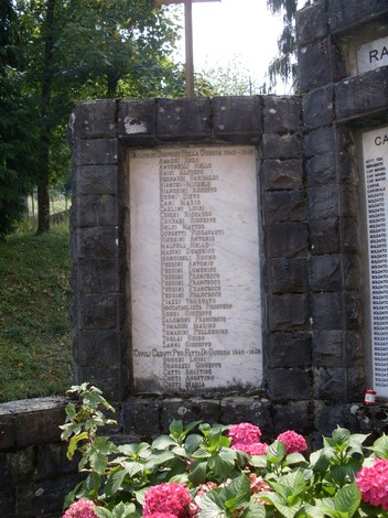 Monumento ai Caduti di Ramiseto, in memoria dei soldati e civili sacrificati nel conflitto. Fiori decorativi in primo piano.